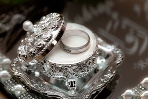 Elegant diamond and pearl wedding jewelry details on reflective surface.
