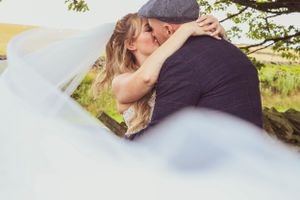 Couple sharing an intimate moment while lying together outdoors.
