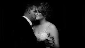 An intimate black and white portrait of a couple sharing a romantic dance moment.