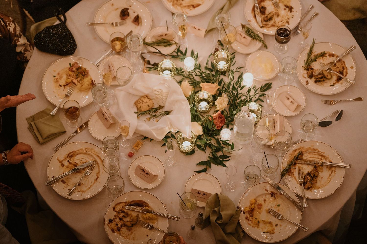Aerial view of a round wedding reception table with elegant place settings and floral centerpiece.