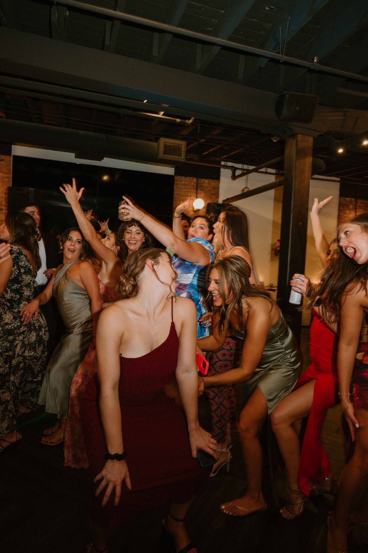 Energetic wedding guests dancing and celebrating together on the dance floor at a lively reception party.