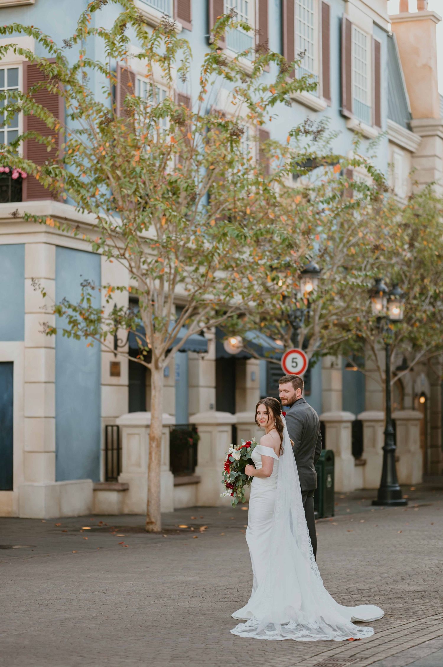 Bride and groom pose on a charming European-style street during their Disney Epcot wedding photo session.