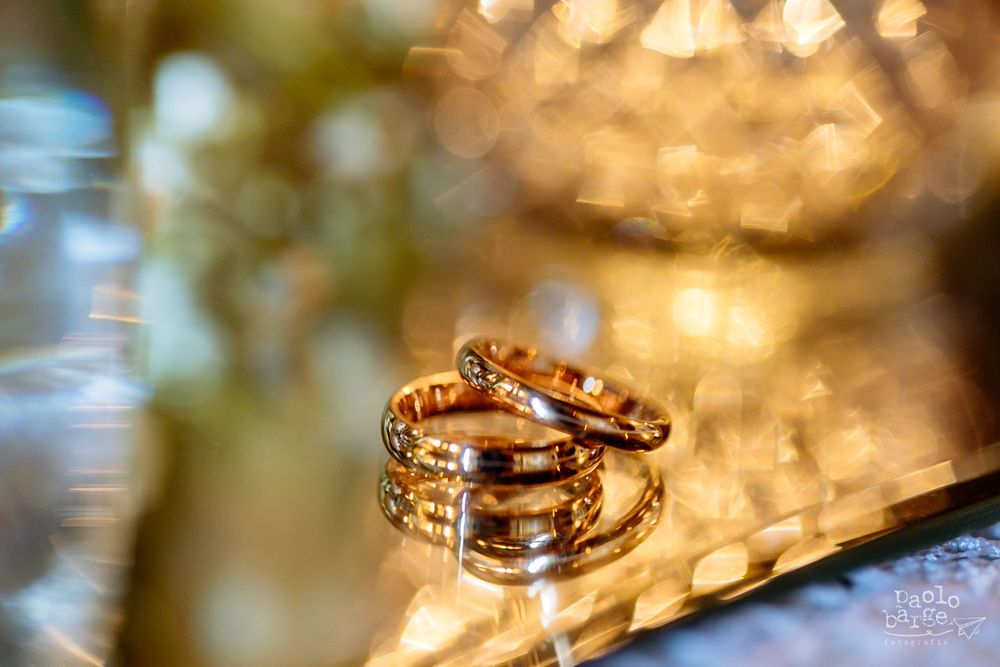 Wedding rings sparkle with bokeh lighting in an elegant macro photograph.