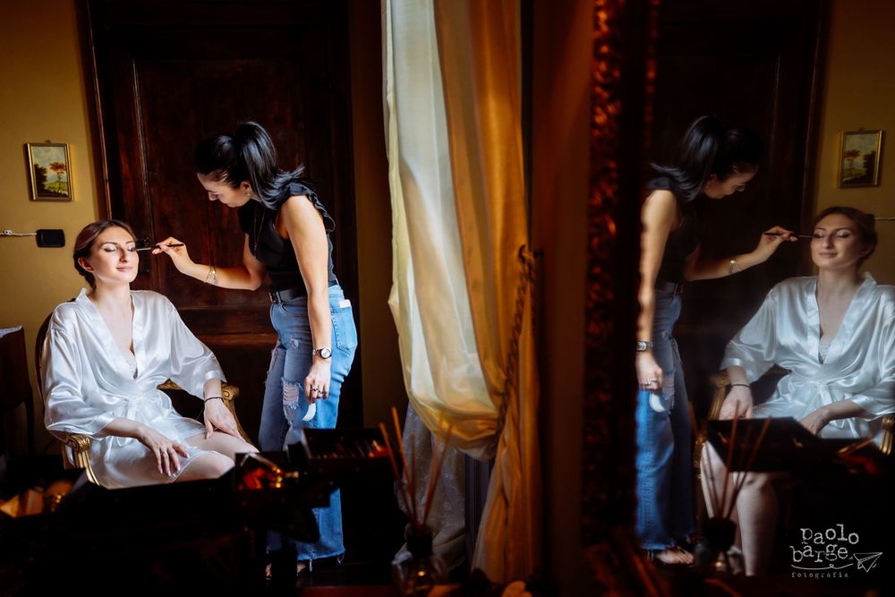 Mirror reflection showing wedding day preparation in elegant room with warm lighting.