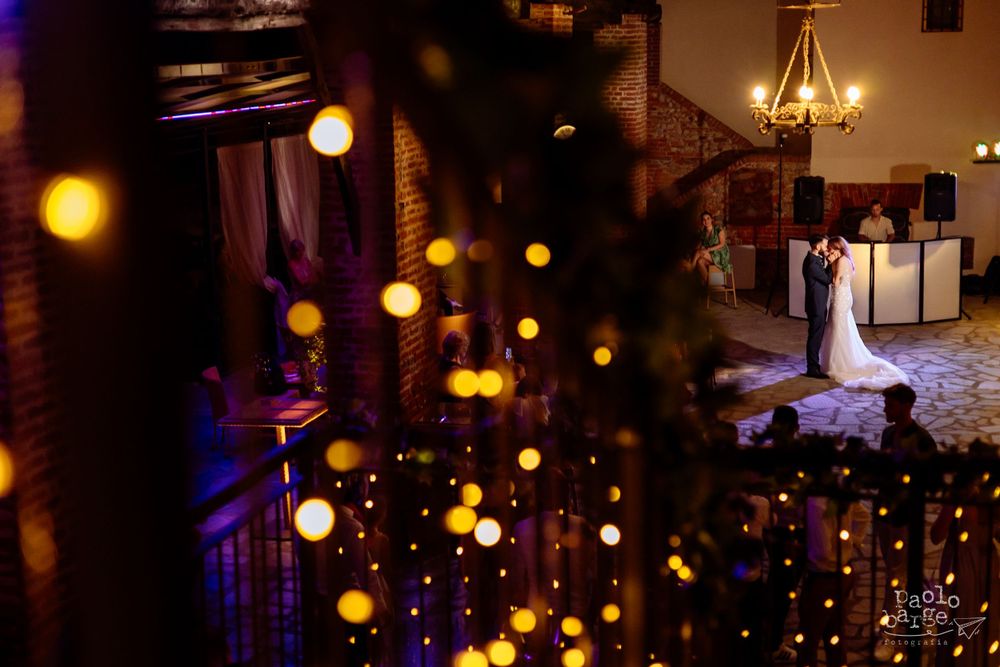 Romantic wedding venue interior decorated with glowing string lights creating magical bokeh effect.