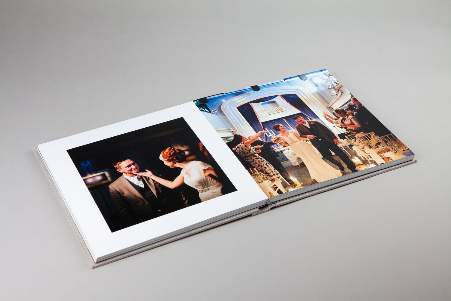 An open wedding photo album displaying black and white ceremony photographs.
