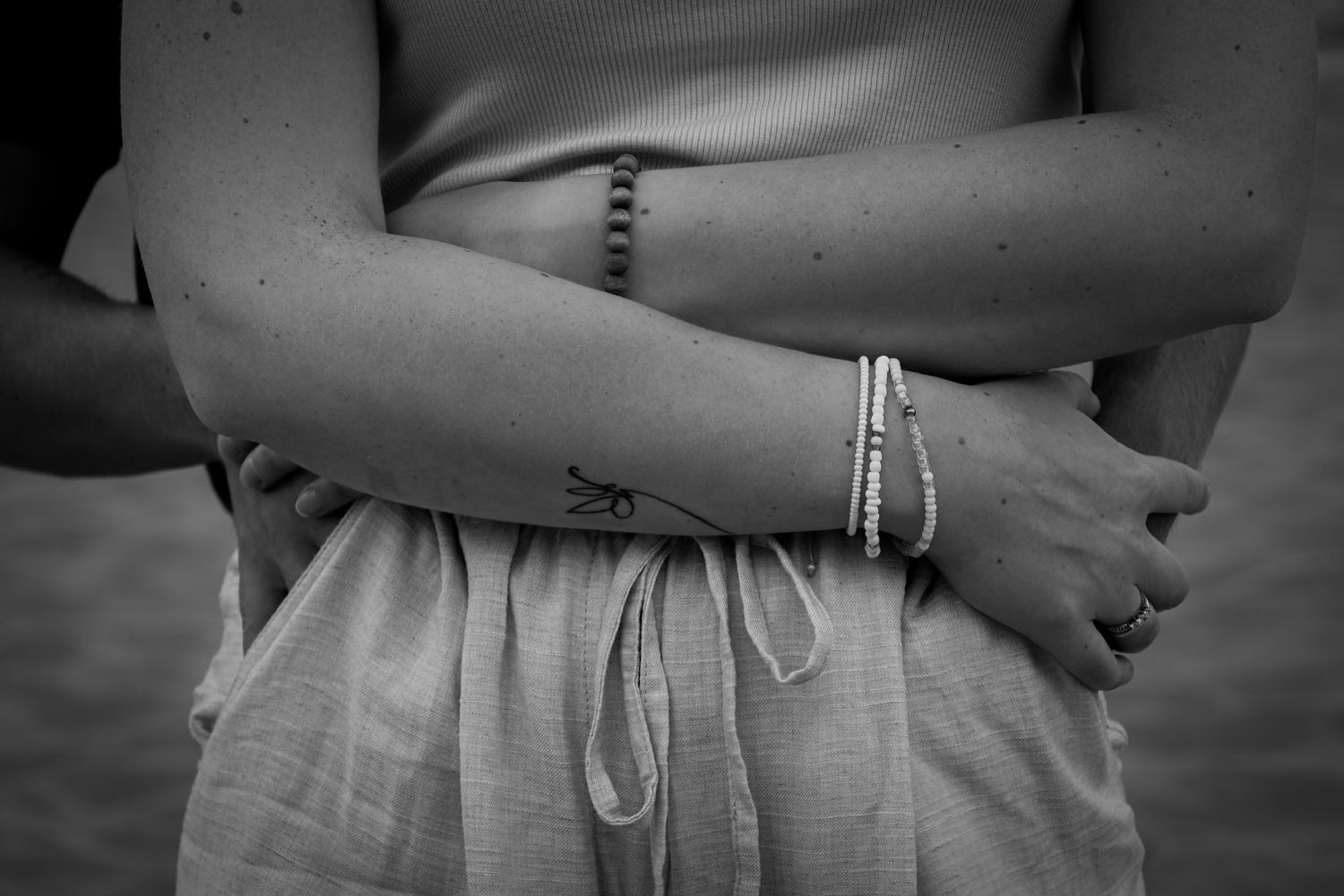 Black and white detail shot of hands resting on hips.