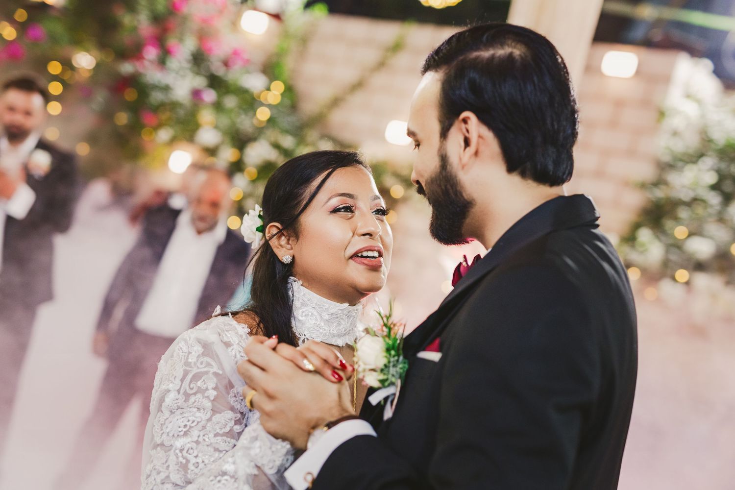 Couple sharing an intimate dance moment under romantic lighting at their reception.