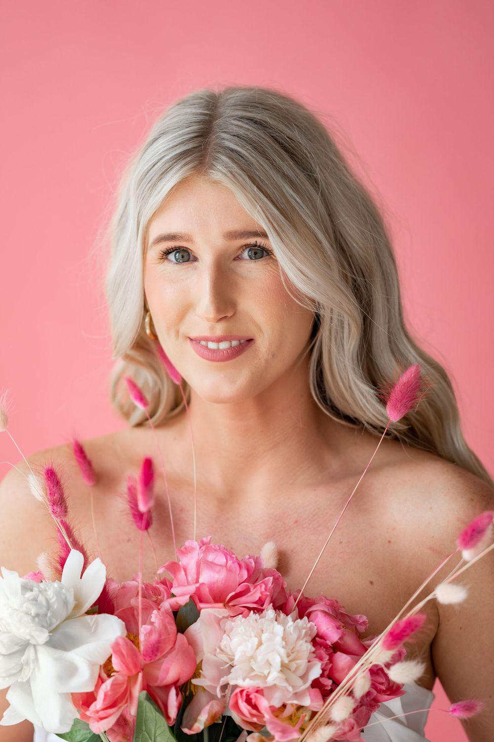 Spring portrait with pink and white flowers against coral background.