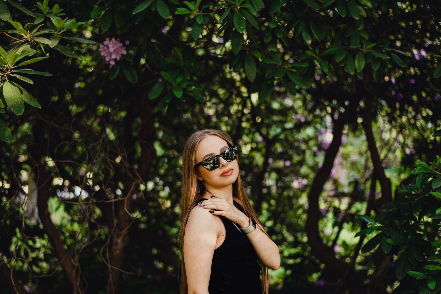 A portrait taken in a lush garden setting with green foliage background.