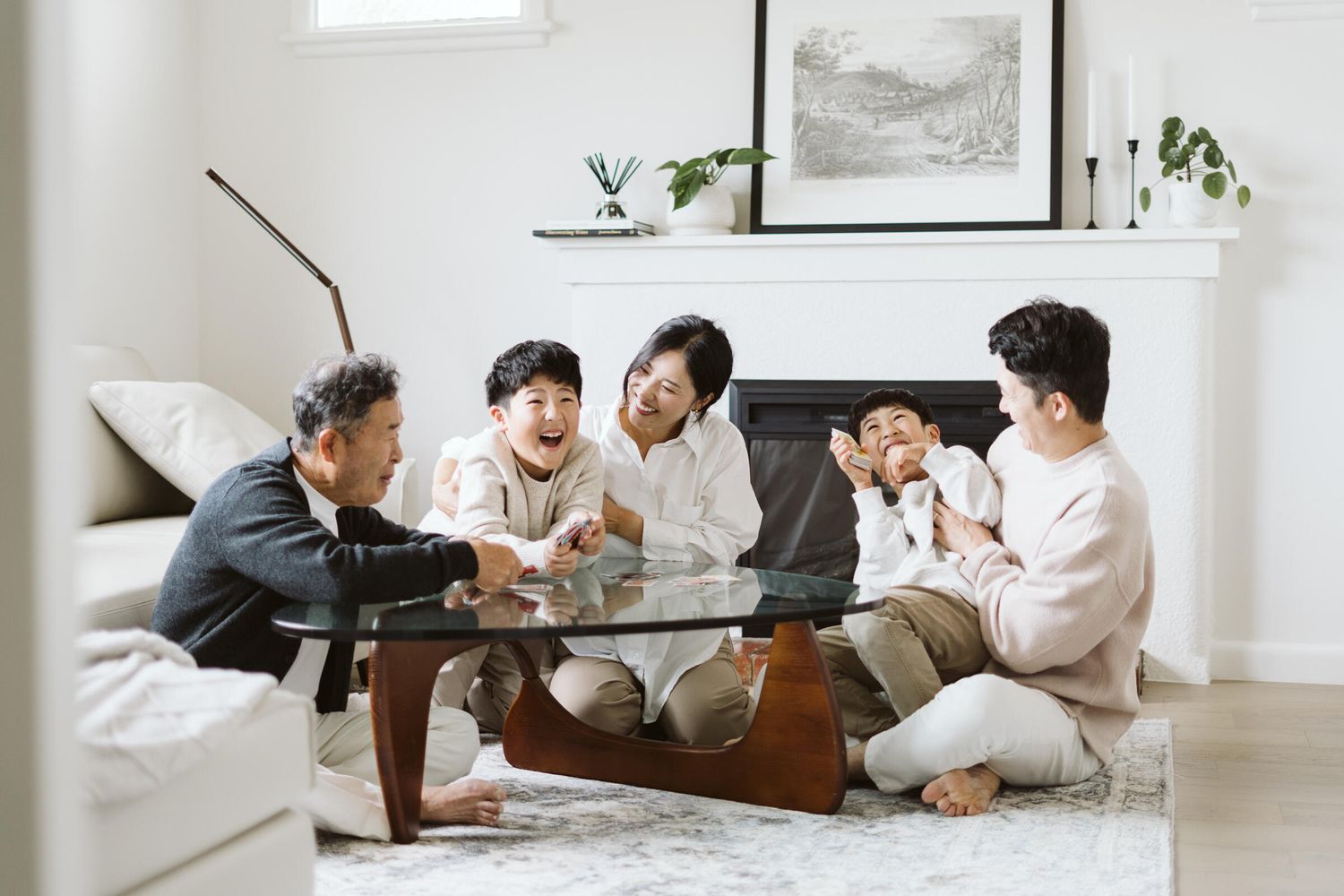 Grandfather and family playing UNO cards at the table, laughing together.