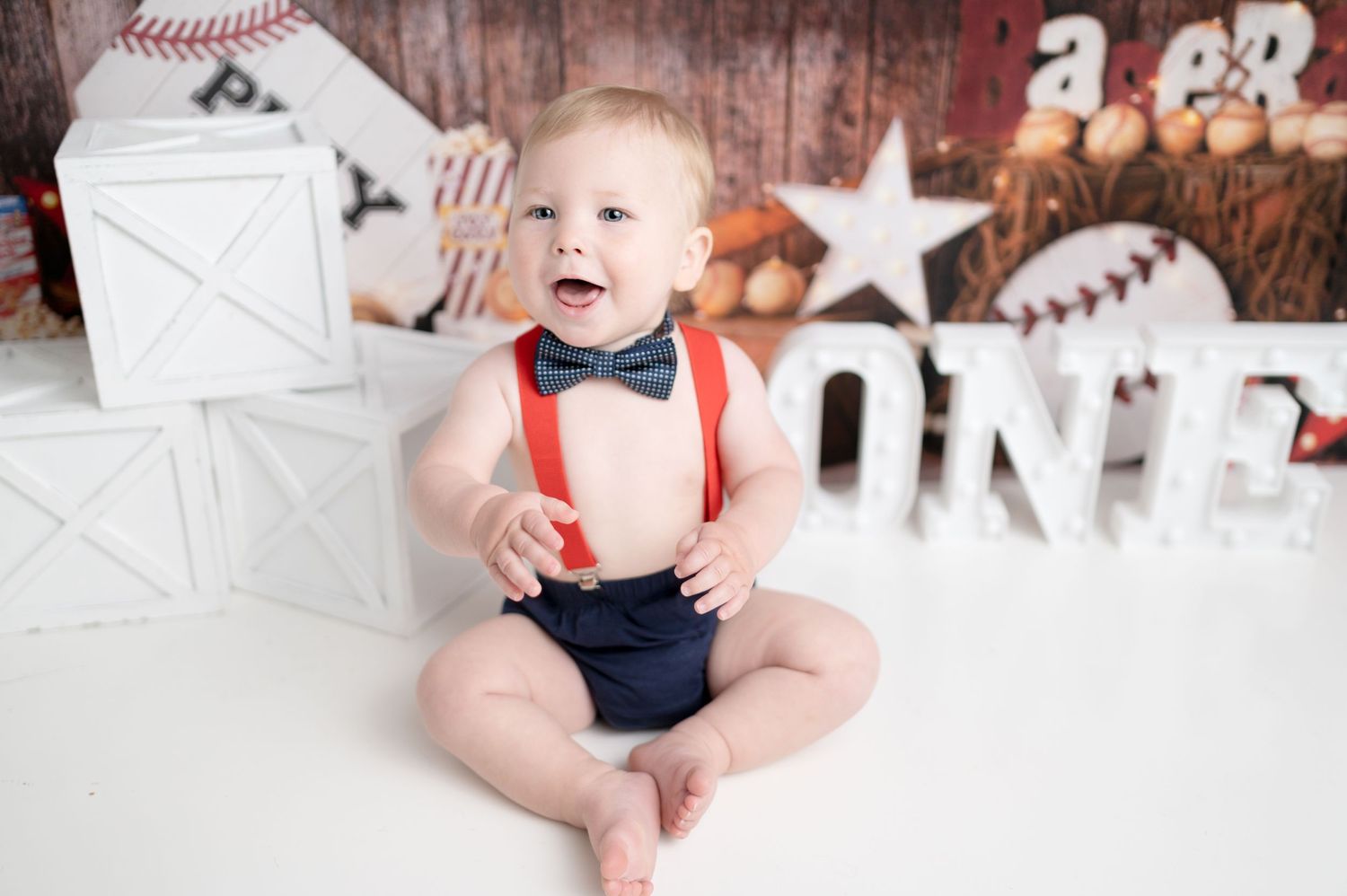 Baseball themed photo session with rustic wood backdrop and decorative white stars.