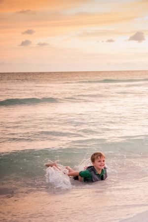 kid playing in water during fun family portrait session at sunset on Panama City Beach Florida