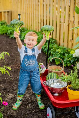 Garden photoshoot boy holding broccoli he grew children photography Panama City Florida