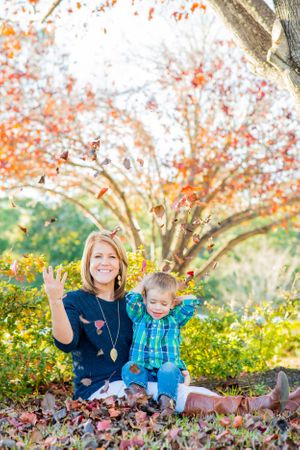 boy & Mom tossing leaves during fun family photo session in Panama City Florid