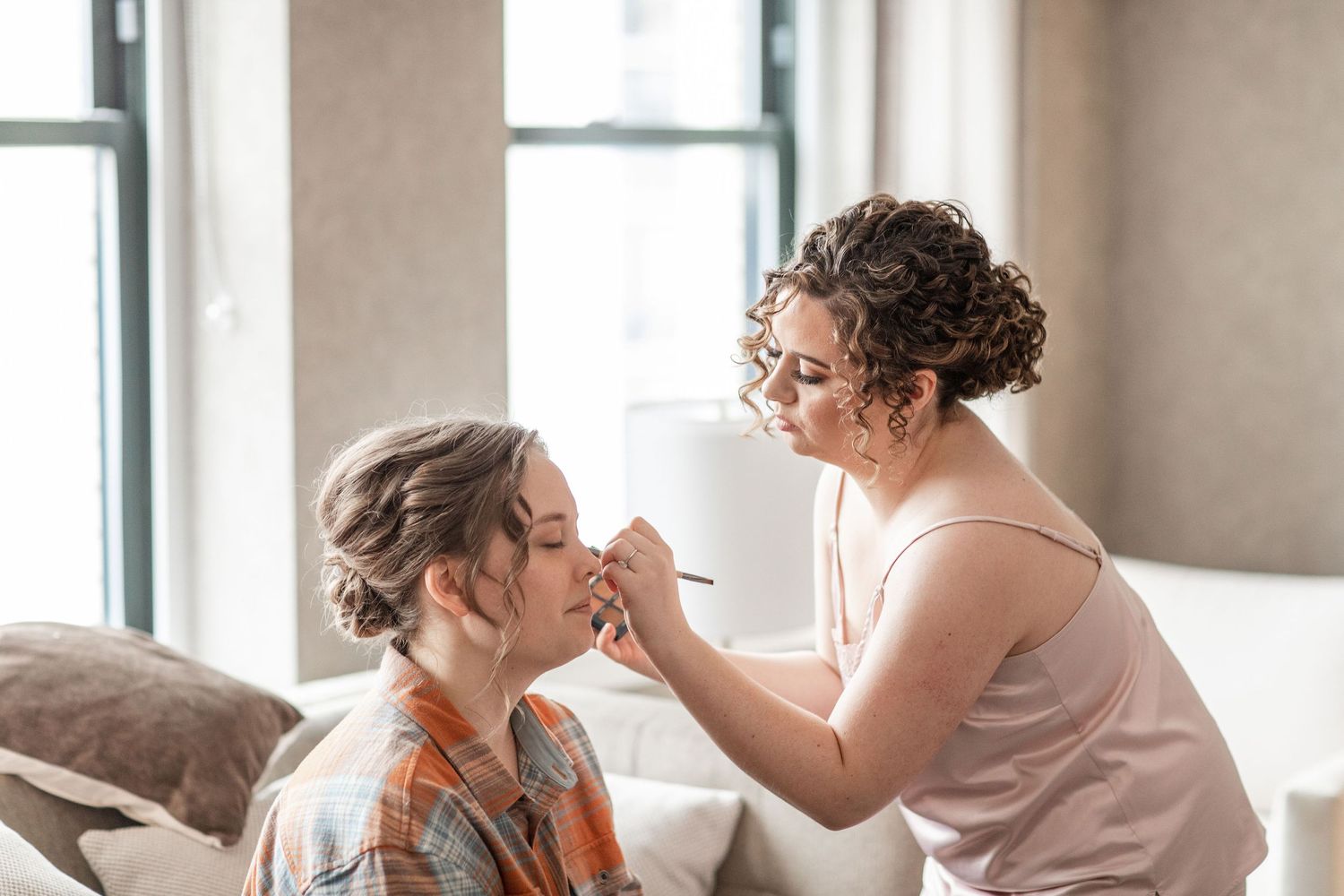 Getting ready scene with makeup application in a bright, modern room.