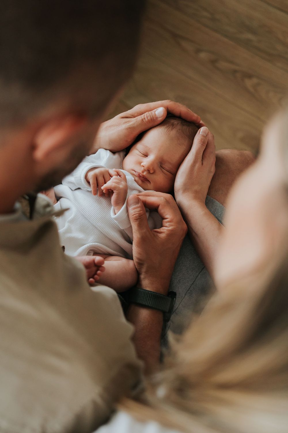 rodzice tulący noworodka podczas sesji lifestyle - fotograf noworodkowy Kraków