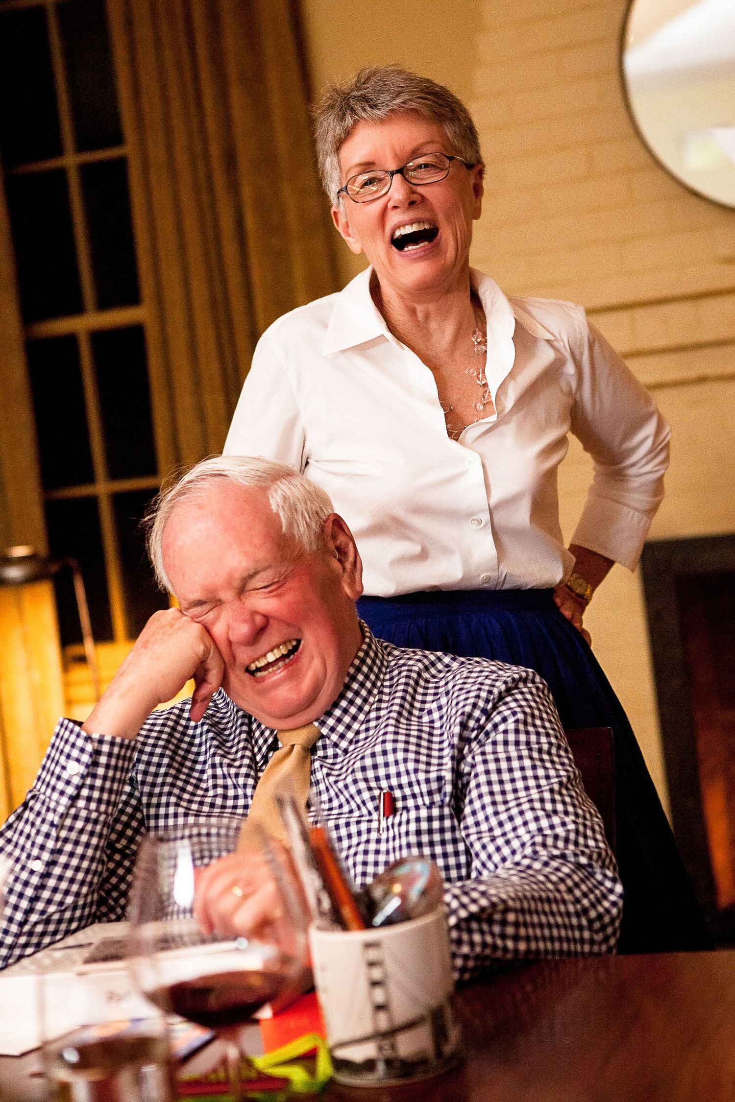 Senior couple laughing together during dinner at home.