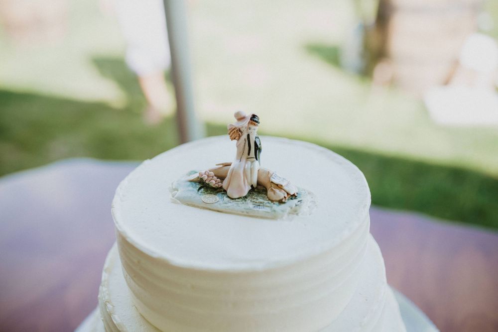 Small wedding cake topper on a simple white frosted cake.