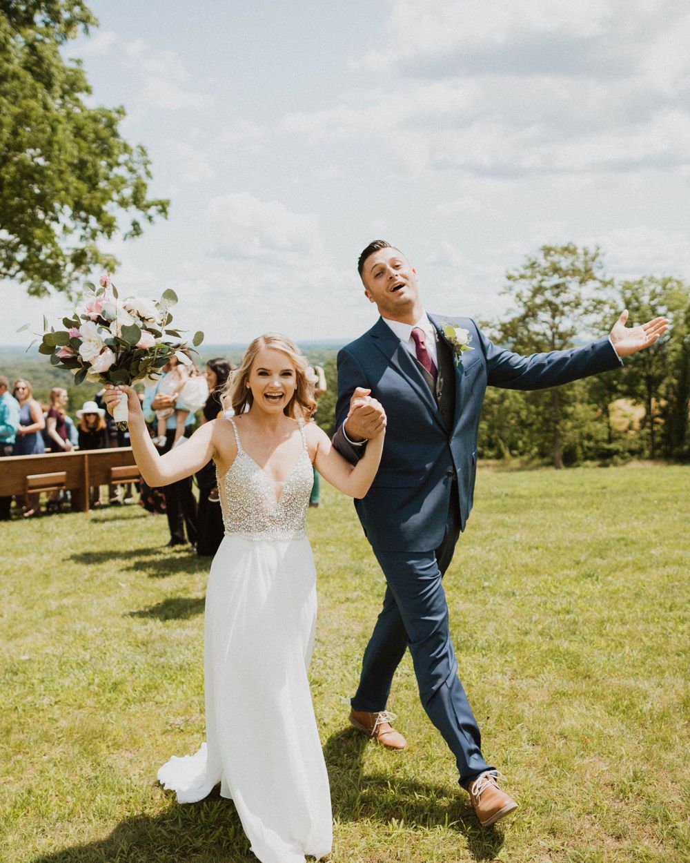 Newlyweds celebrating with joyful expressions during outdoor wedding ceremony.