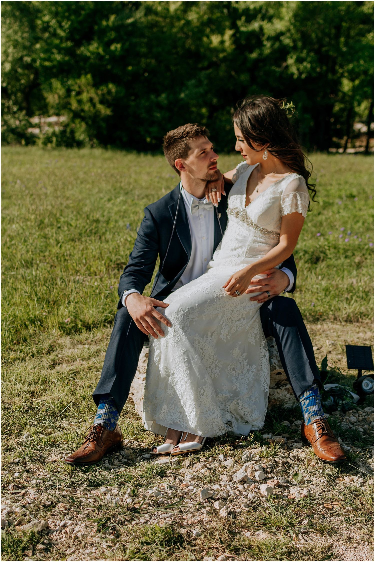 A romantic moment captured between newlyweds sitting outdoors.