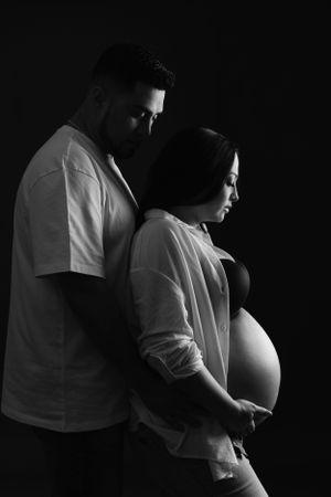 Intimate black and white maternity portrait of couple in minimalist style.