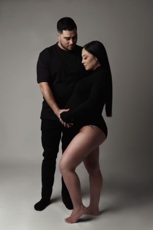 Intimate couple's maternity photo in minimalist black clothing.