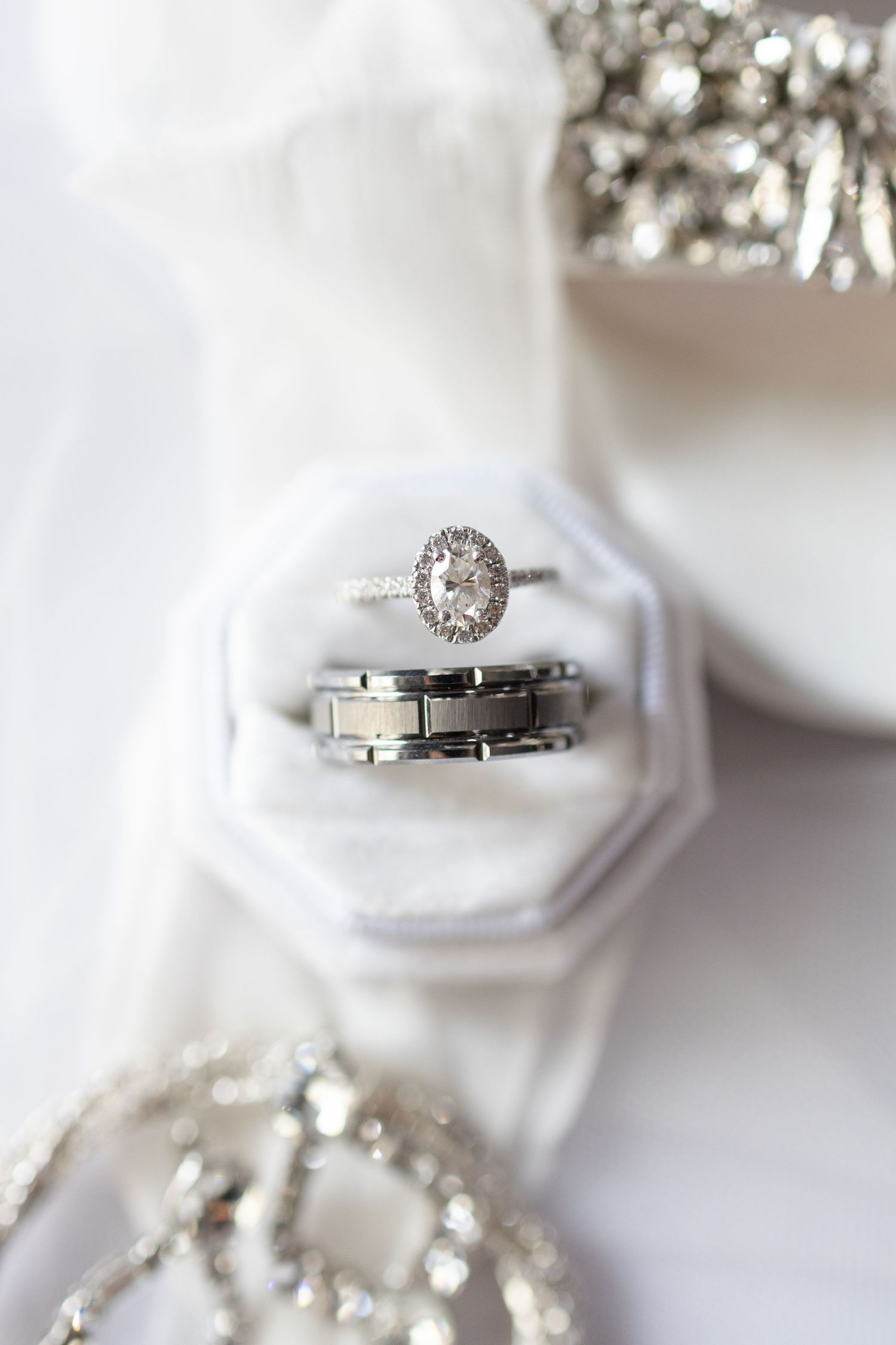 Diamond engagement ring and wedding band displayed in white hexagonal ring box.