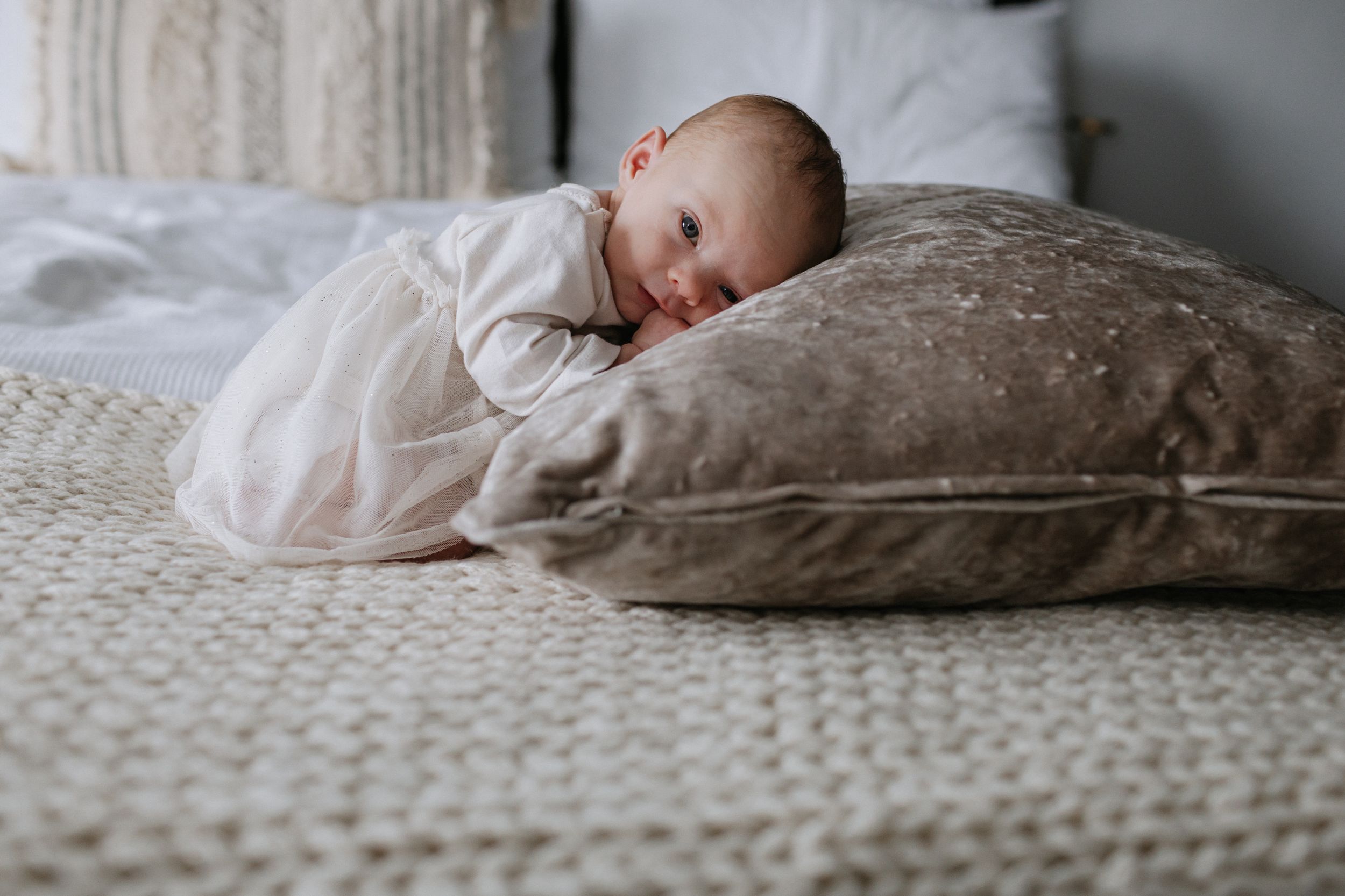 Serene collage of sleeping figures nestled in soft white bedding and textured pillows.