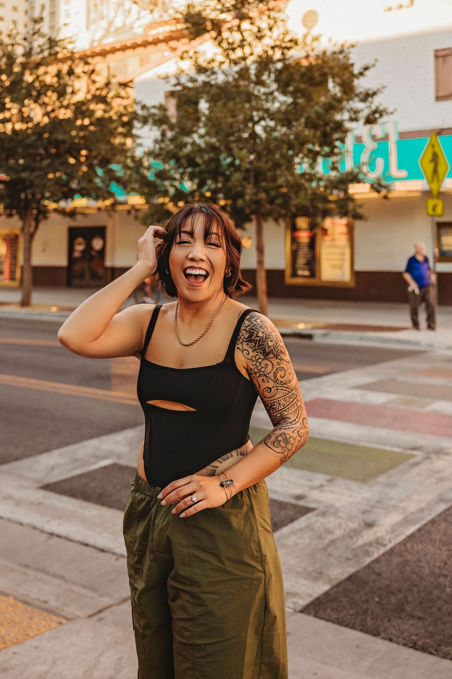 Street fashion portrait with olive cargo pants and black crop top against urban backdrop.