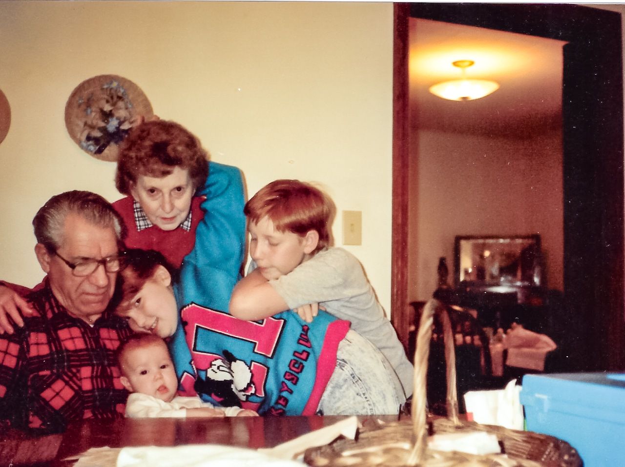 A vintage family photo showing multiple generations gathered around a book during story time.