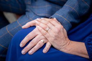 Close-up of hands with rings resting on blue fabric. Bakewell Bath Gardens.