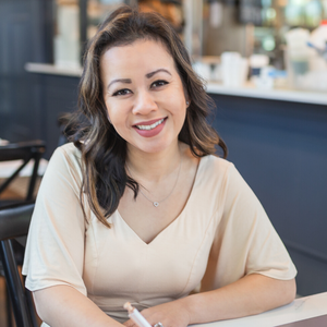 Polly Sla web designer in the Seattle, WA area headshot for guest post woman sitting at table smiling at camera