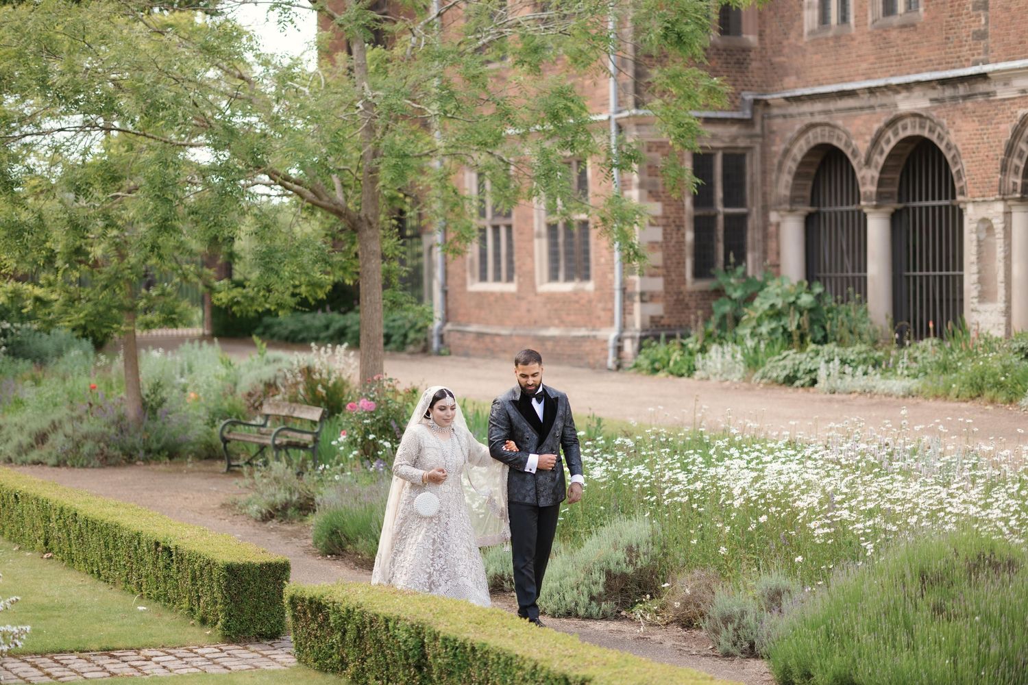 Muslim wedding couple posing for a picture with their Asian wedding photographer.