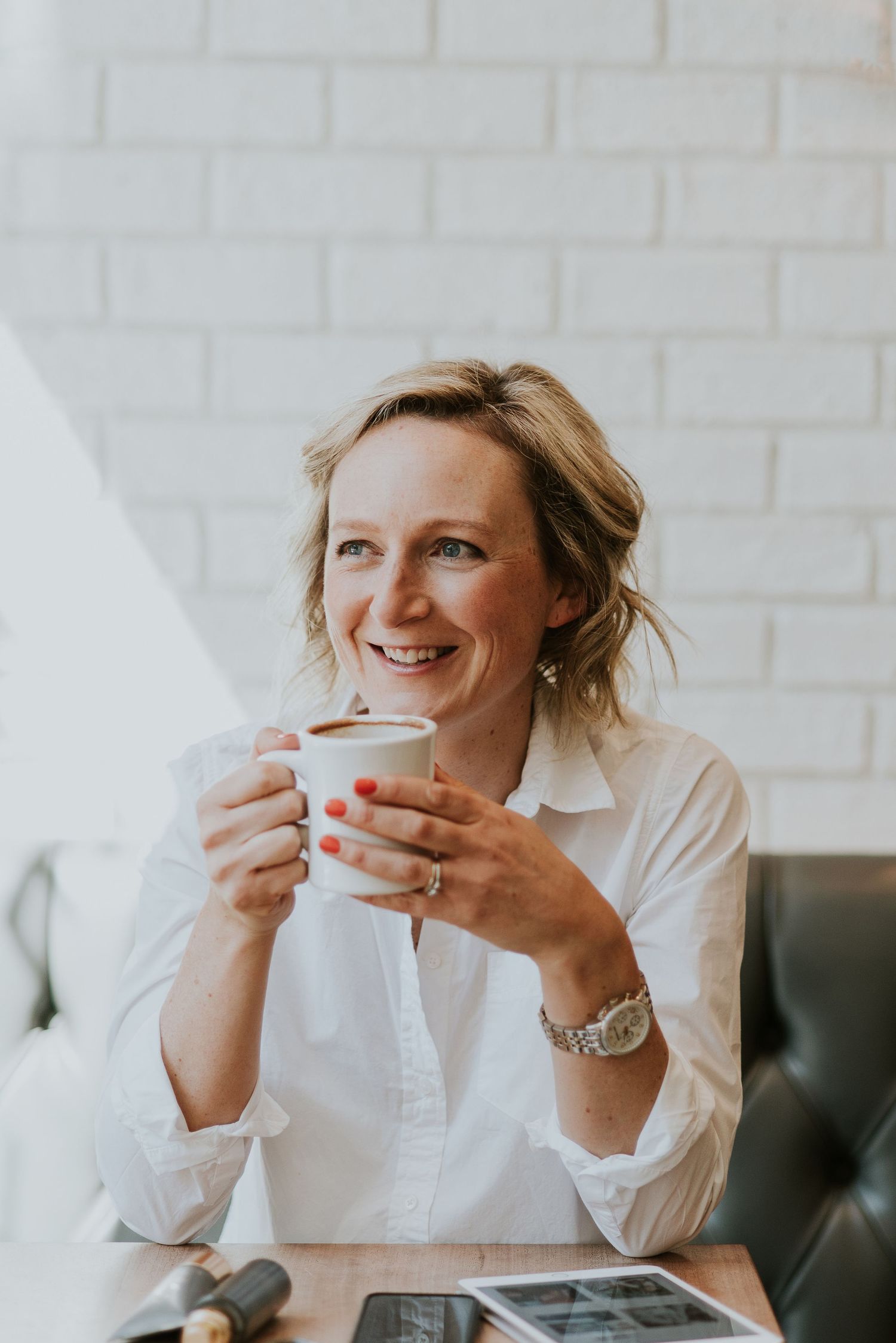 Woman smiling and holding coffee in coffee shop in Deep Cove North Vancouver