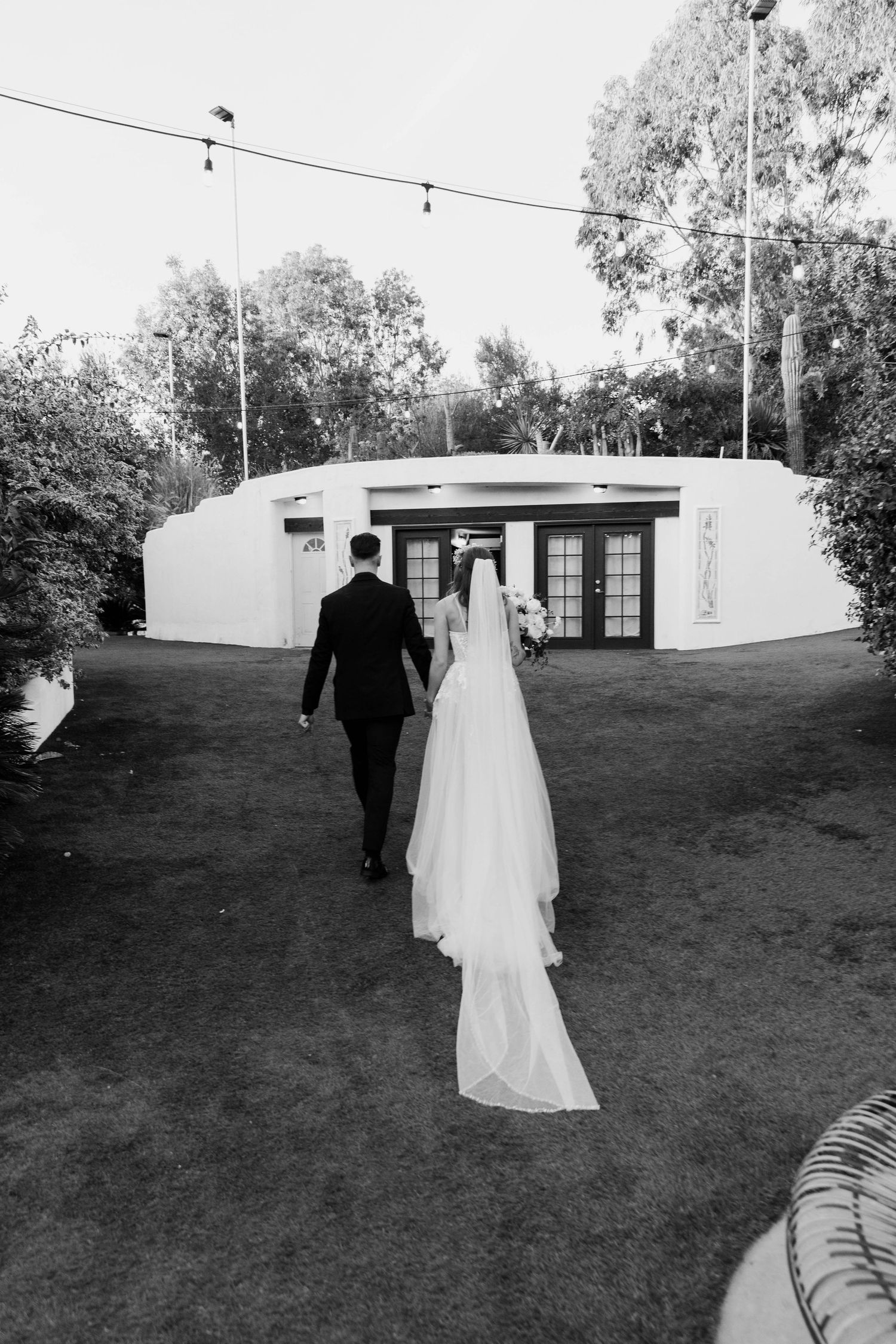 Black and white image of the newlywed bride and groom walking out of their ceremony on their wedding day.