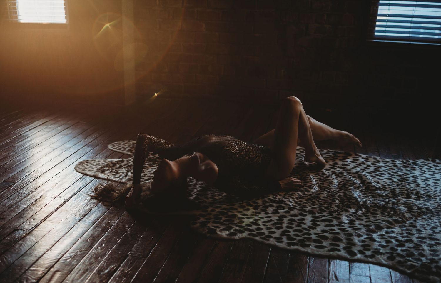 Dramatic lighting creates moody atmosphere in rustic room with wooden floors.
