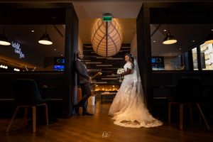 Dramatic wedding photo in a dimly lit restaurant venue with decorative lighting.
