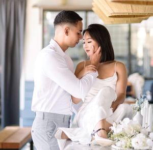 A romantic moment shared between a couple in elegant white attire.