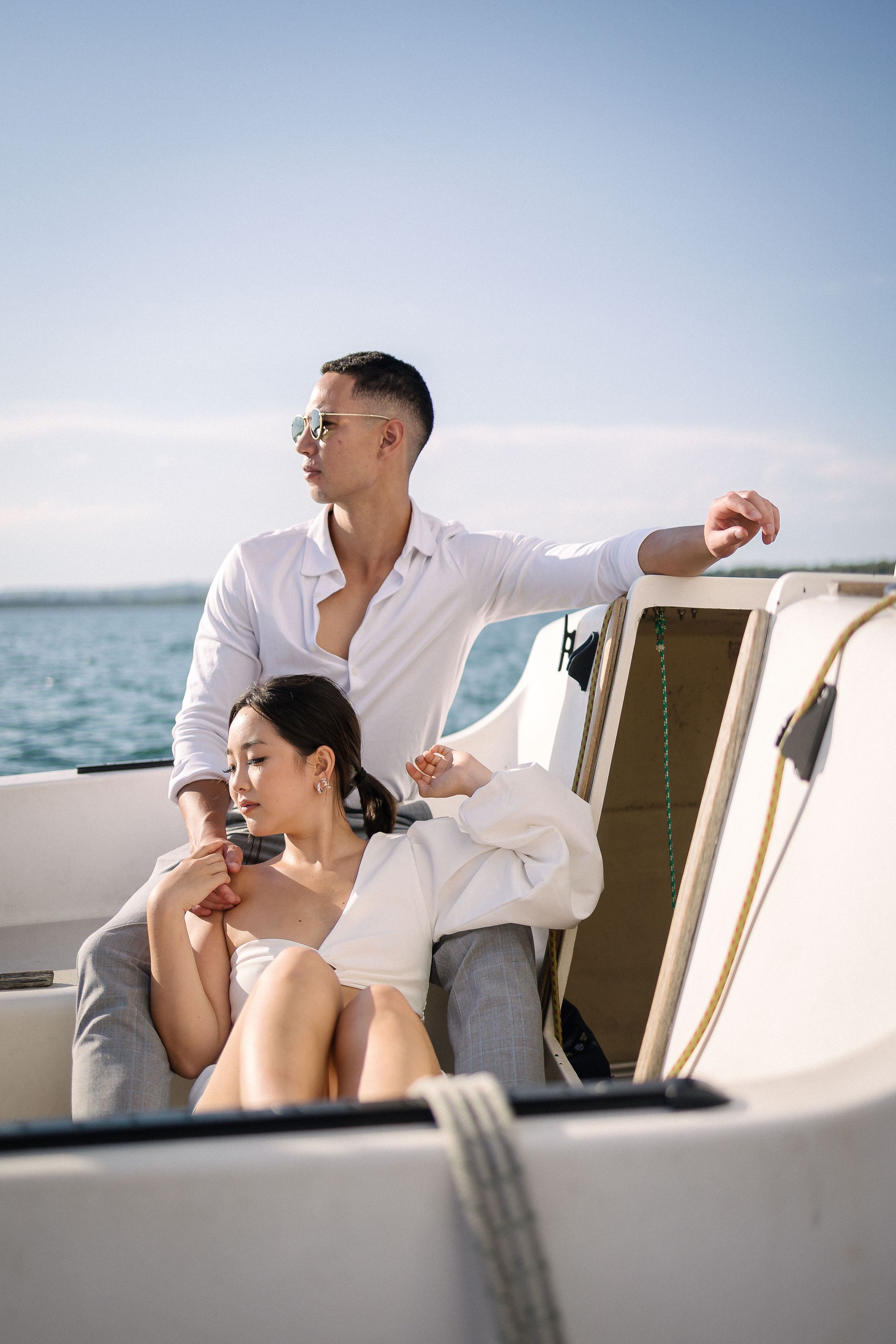 Couple relaxing on a luxury boat sailing across calm waters on a bright sunny day.