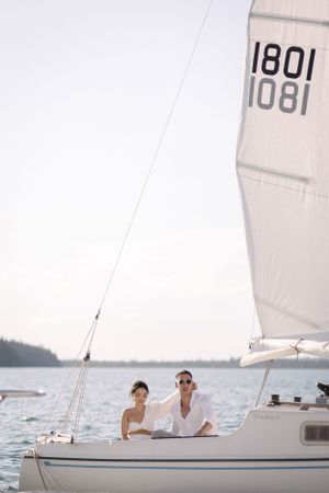 Sailboat with sail number 1801 gliding across serene waters with mountain backdrop.