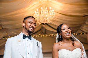 Joyful wedding celebration moment under an elegant crystal chandelier.