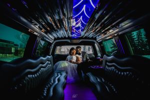 Wedding couple captured in neon-lit luxury limousine interior.