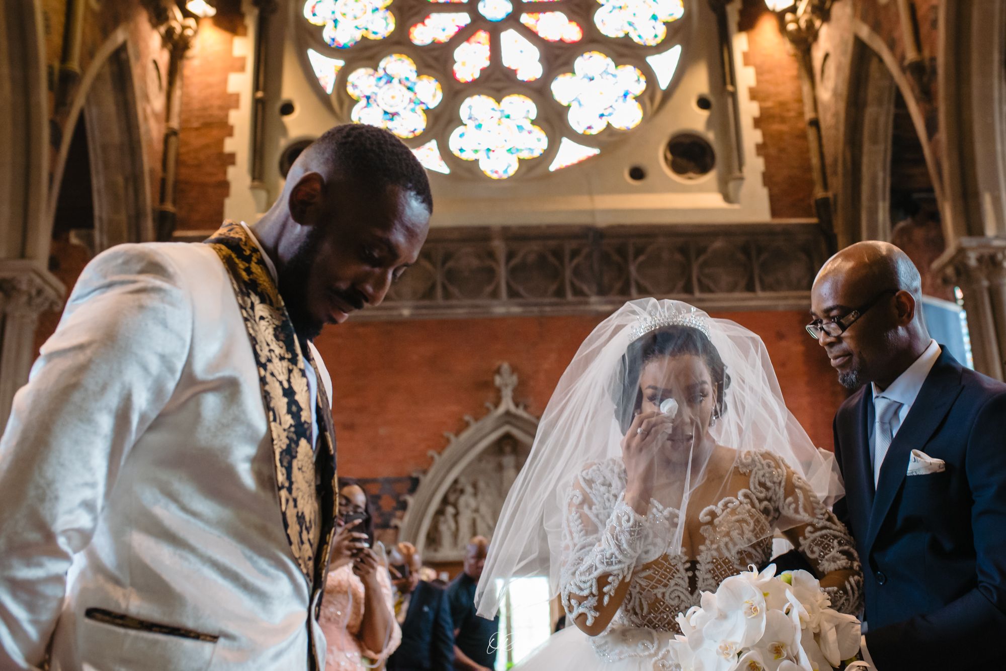 Wedding ceremony in historic church with stained glass rose window.