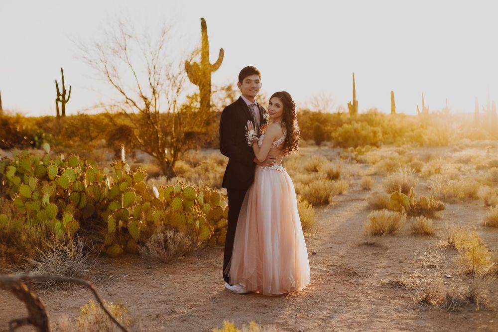 A sunset engagement shoot in the Arizona desert with tall saguaro cacti.