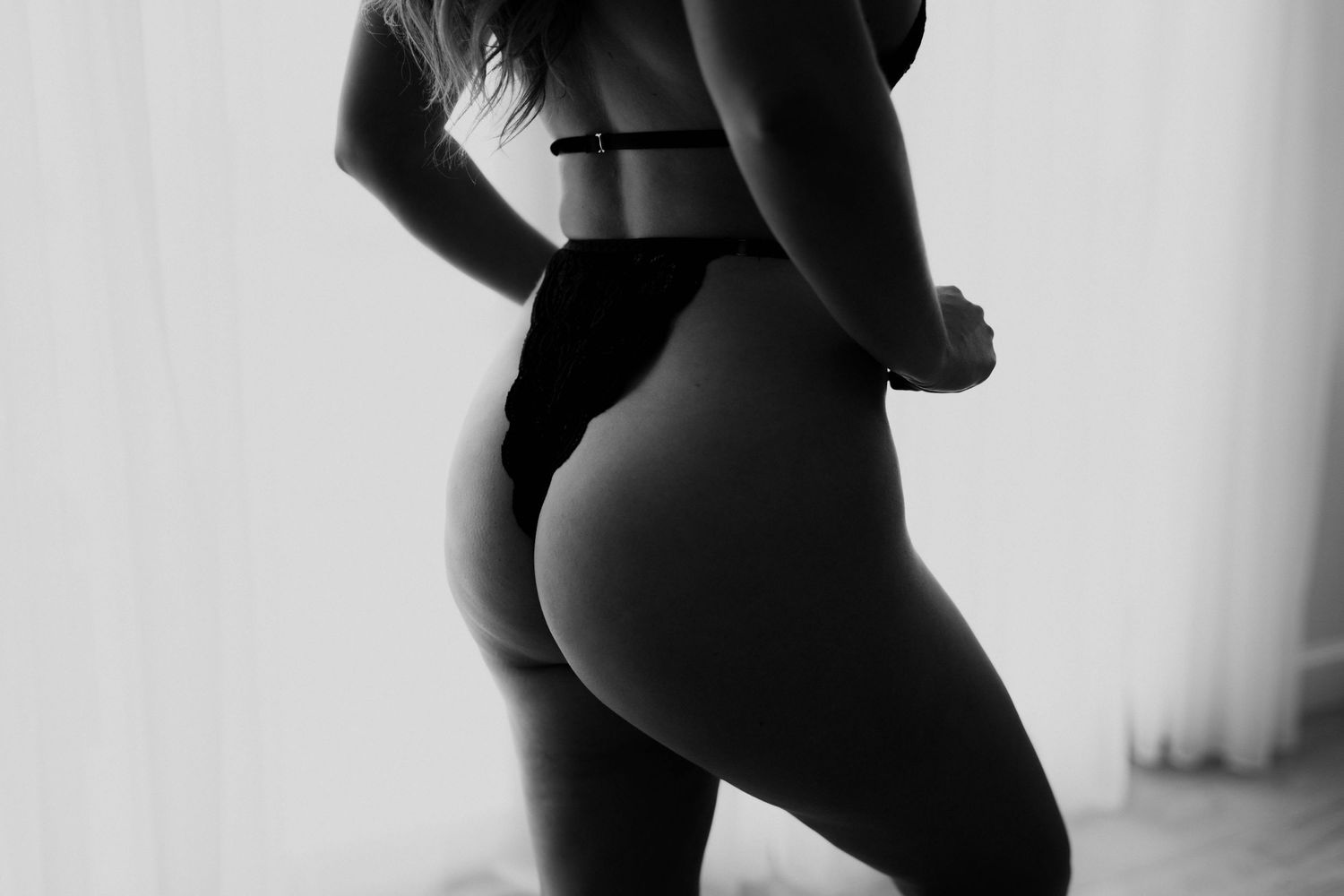 Artistic black and white photograph showing silhouetted curves and contours against a light background.