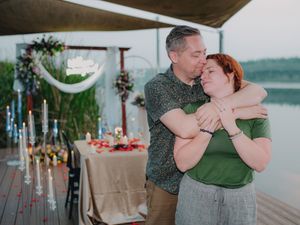 A romantic waterfront deck decorated with flowing fabric, flowers and candles for a special celebration.
