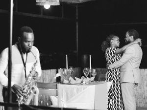 Black and white photo of a jazz club scene with a saxophonist performing while couple dances.