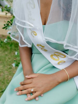 Detail shot of bridal veil and engagement ring with mint green dress.