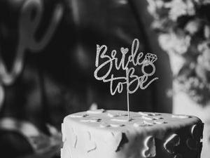 A black and white detail shot of a cake topper reading 'Bride to Be'.